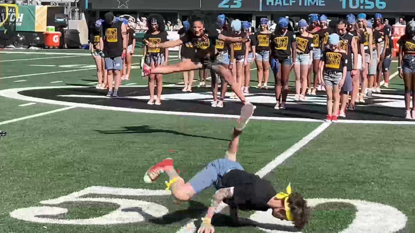 IKONIK dancer performing a floor move on the fifty yard line